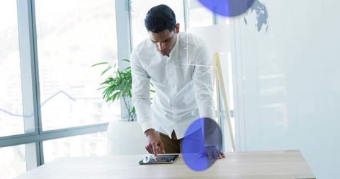 Businessman Using Tablet in Modern Office with Data Graphics