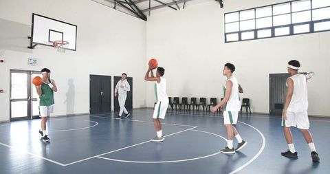 Male Basketball Team Practicing Jump Shots in Indoor Gym