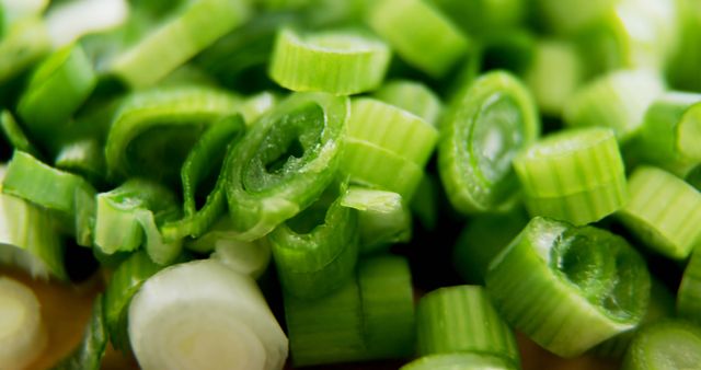 This close-up captures chopped green onions on a cutting board, emphasizing their freshness and vibrant green color. Perfect for use in food blogs, recipe websites, cooking tutorials, or marketing materials for fresh produce. Highlights the importance of fresh ingredients in cooking.