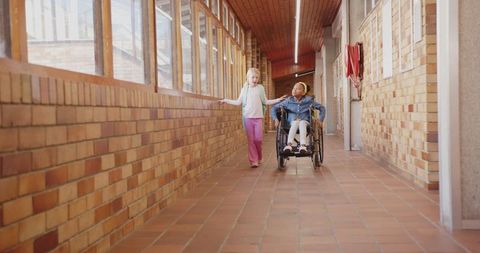 Girls sharing joyful moment in school hallway, embracing inclusivity