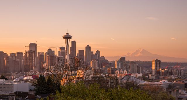 Seattle stands out against a beautiful orange sunset, featuring the Space Needle and downtown skyscrapers. Perfect for travel promotions, panoramic city posters, and Seattle memorabilia.