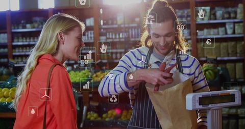Grocery clerk packing fresh produce with eco-friendly icons