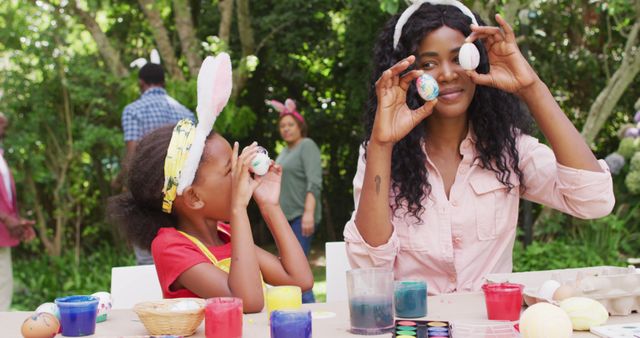 Image of happy african american mother and daughter painting easter eggs outdoors, having fun - Download Free Stock Photos Pikwizard.com