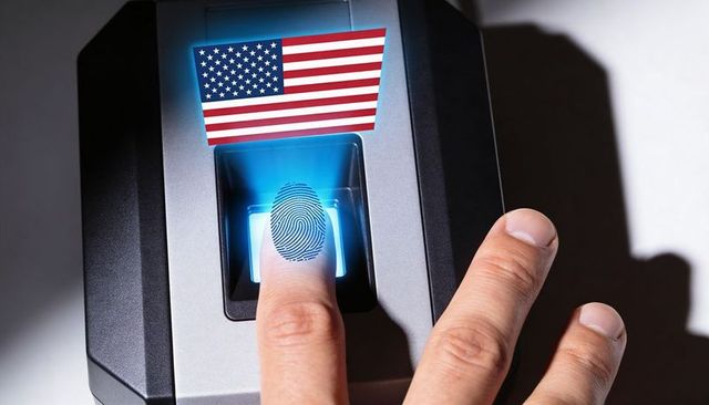 Pressing index finger on biometric scanner with us flag overlay for secure access