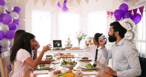 Multiracial family enjoying festive meal at home celebration