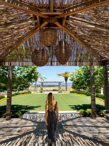 Woman Walking Under Pergola in Tropical Garden
