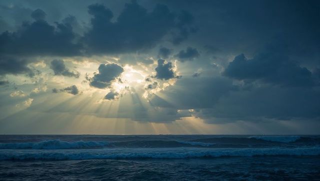 Dramatic Sunlight Breaking Through Stormy Ocean Clouds