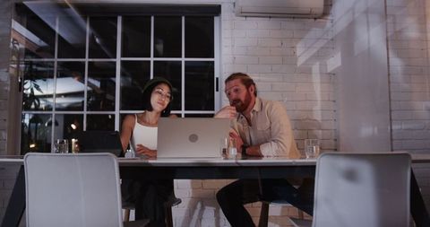 Diverse colleagues brainstorming at night in creative workspace