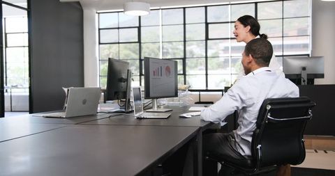 Colleagues sharing success in modern office environment