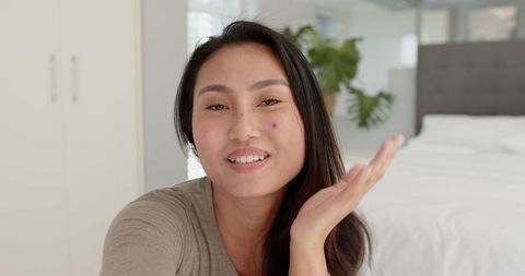 Smiling woman enjoying minimalist bedroom environment