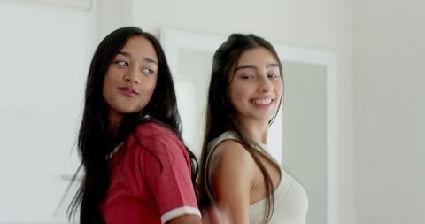 Joyful Female Friends Dancing in Modern White Interior