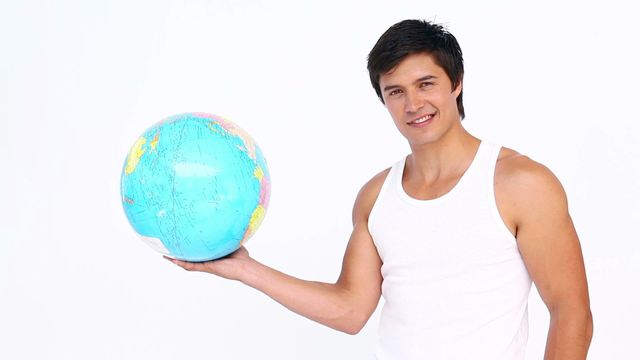 This video features a man in athletic wear holding a globe confidently with a smile. The white background emphasizes the subject, making it ideal for use in fitness, travel, global studies, or educational content where conveying energy and confidence is crucial.