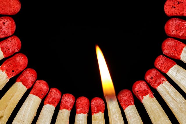 Close-Up of Lit Match Among Unlit Matches on Black Background - Download Free Stock Photos Pikwizard.com