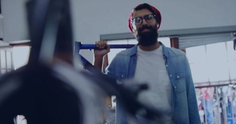 Bearded man with red beanie in bicycle workshop
