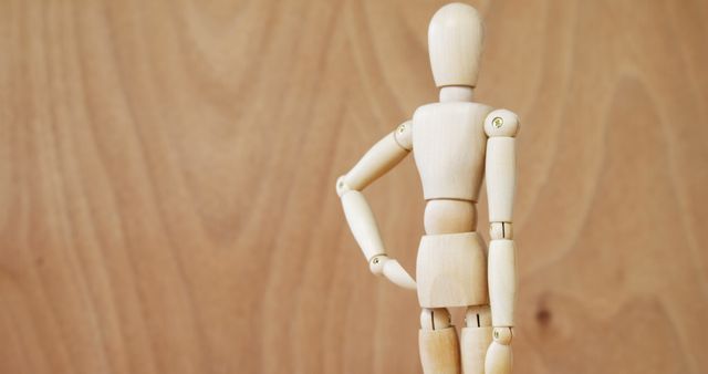 An artist's wooden mannequin is posed for reference against a plain background with space for text. - Download Free Stock Photos Pikwizard.com