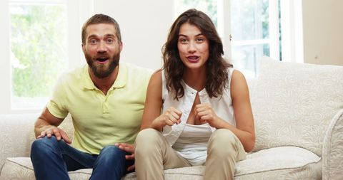 Excited Couple Enthralled with Television Show