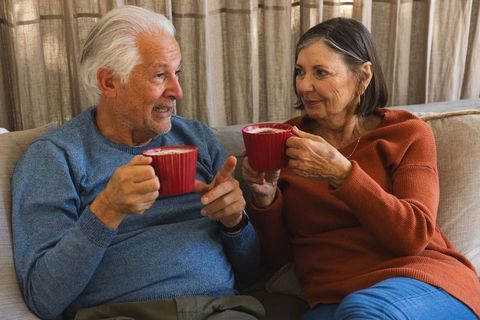 Senior Couple Relaxing with Coffee on Comfortable Sofa