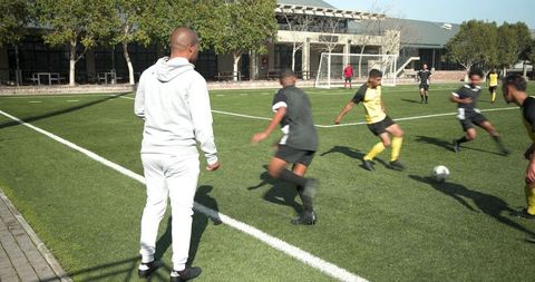 Coach Guiding Young Soccer Players During Practice on Field