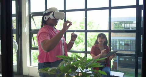 African american colleagues testing vr headset, collaborating with tablet in bright office