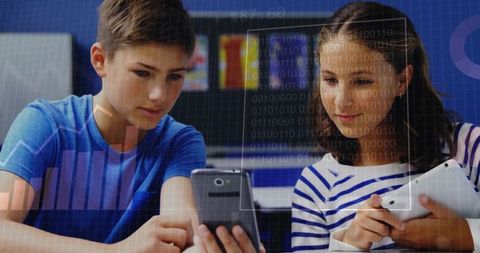 Teen students collaborating with smartphone and tablet in modern digital classroom learning
