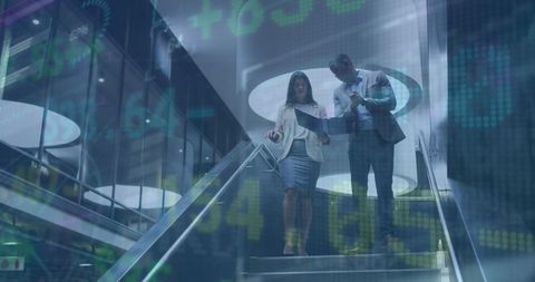 Coworkers Analyzing Reports With Stock Market Overlay in Modern Office