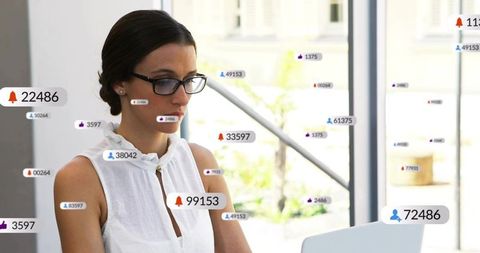 Businesswoman typing on laptop with floating social notifications showing engagement growth