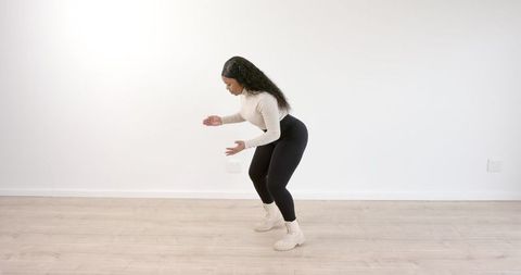 Woman practicing dance in minimalist studio setting