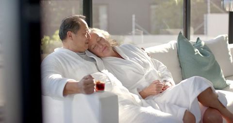 Senior Couple Relaxing on Balcony in White Bathrobes