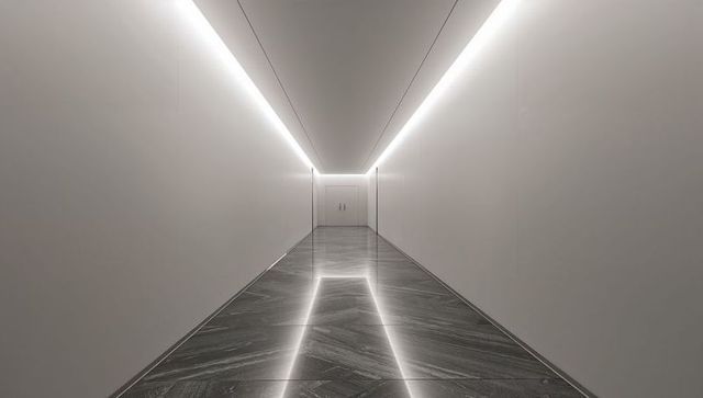 Minimalist led-lit corridor with reflective marble floor guiding toward closed double doors