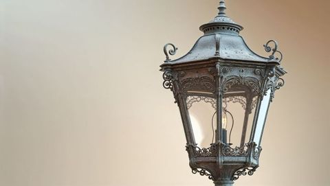 Ornate metal lantern with glowing bulb in trieste, italy
