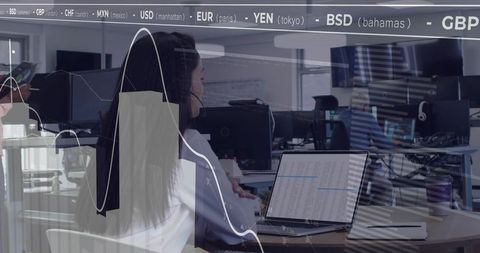 Female professional analyzing financial data on laptop in open office with currency feed