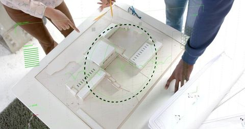 Designing architectural scale model and tracing centerline with pencil, collaborative team