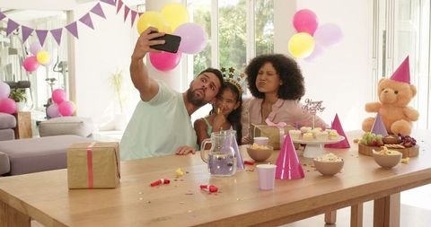 Happy family celebrates birthday with cake and gifts