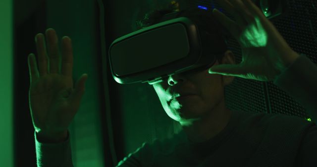 Depicting a person using advanced virtual reality technology with green lighting effects. Suitable for promoting VR technology, gaming industries, digital entertainment advertisements, futuristic tech presentations, or any content related to immersive experience.