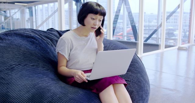 Young Woman Working Remotely on Laptop While Talking on Phone - Download Free Stock Images Pikwizard.com