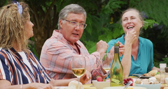 Image of happy caucasian senior female and male friends talking at lunch in garden - Download Free Stock Photos Pikwizard.com