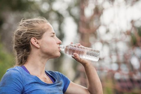 Woman Drinking Water During Outdoor Obstacle Course Challenge