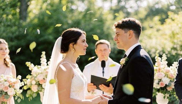 Romantic outdoor wedding ceremony exchanging vows bride in lace gown veil groom in suit