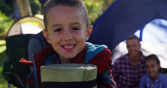 Excited Boy Holding Sleeping Bag at Camping Trip with Family - Download Free Stock Images Pikwizard.com