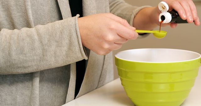 Close-Up of Person Adding Vanilla Extract to Green Mixing Bowl - Download Free Stock Images Pikwizard.com