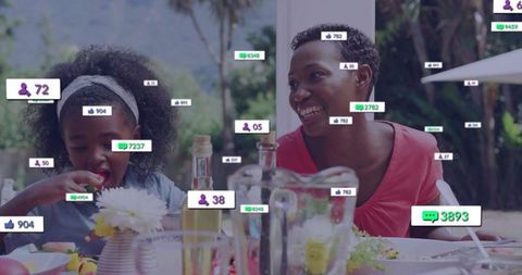 Black mother and daughter enjoying backyard alfresco meal with social media engagement tags