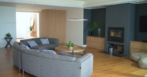 Curved grey sectional anchoring contemporary living room with round coffee table and fireplace