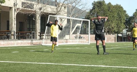 Youth Soccer Practice Near School Buildings on Sunny Day