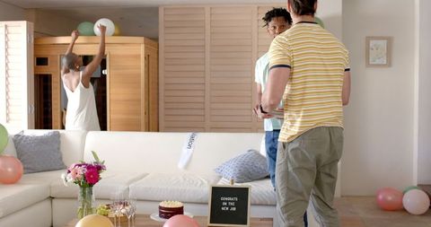 Friends celebrating together at home with decorations and balloons