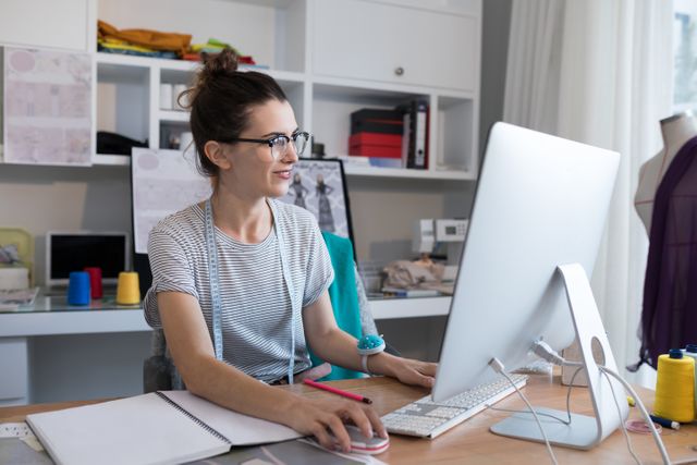 Female designer working on personal computer at desk