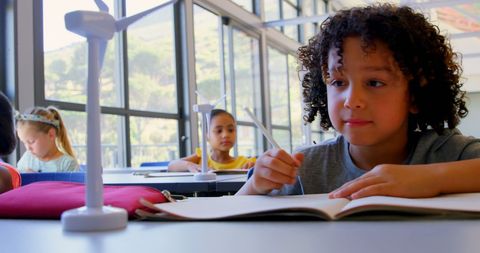 Diverse schoolchildren studying renewable energy in classroom