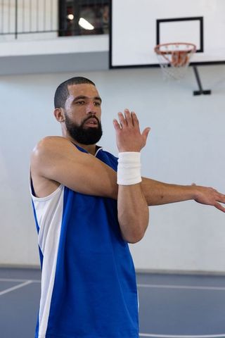 Athlete Stretching on Basketball Court Emphasizing Fitness and Vitality