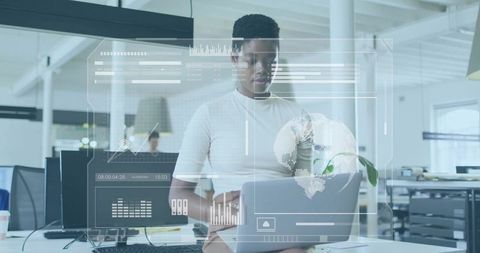 Black Woman Analyzing Global Data on Laptop in Modern Open Office with Virtual HUD
