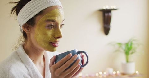 Smiling Woman Relaxing with Face Mask and Coffee at Home