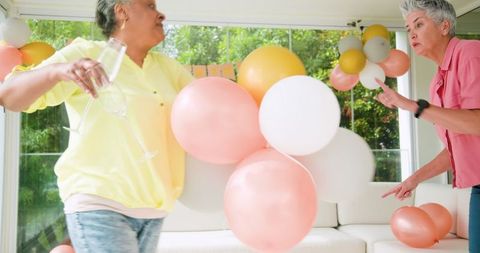 Senior Lesbian Couple Tidying Up After Celebration